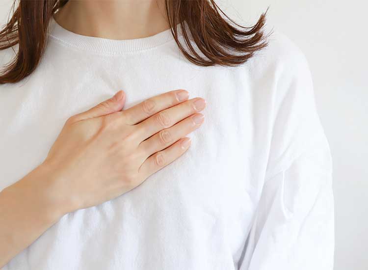 胸に手を当てる女性